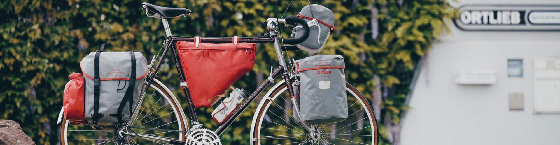 La photo montre un vélo de route en acier qui est équipé de diverses sacoches pour le bikepacking d'Ortlieb.