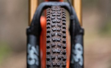 La photo montre le profil d'un pneu de VTT. Le cadrage montre le vélo de face, de sorte que toute la largeur du pneu est visible. 