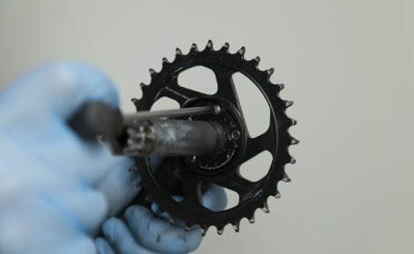 The chainring is being bolted to the right crank arm.