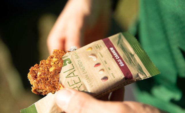 A man opens a Vegan Energy bar from Power Bar.