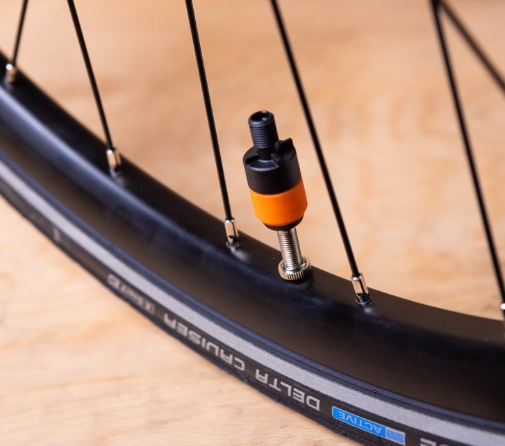 Close-up: A Clik Valve pump adapter is attached to a mounted bicycle valve.
