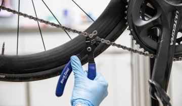 Thomas, mecánico de bc abriendo el cierre de cadena de una bicicleta de ruta.