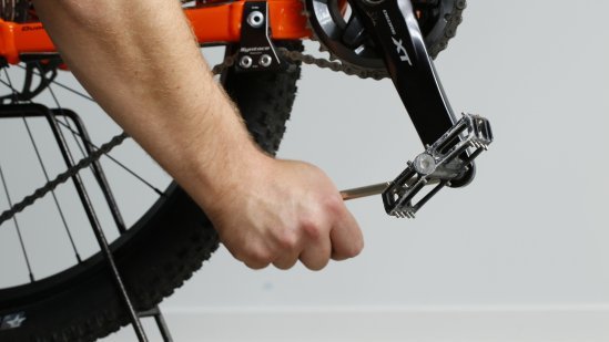 Mechaniker:in löst das rechte Pedal. 