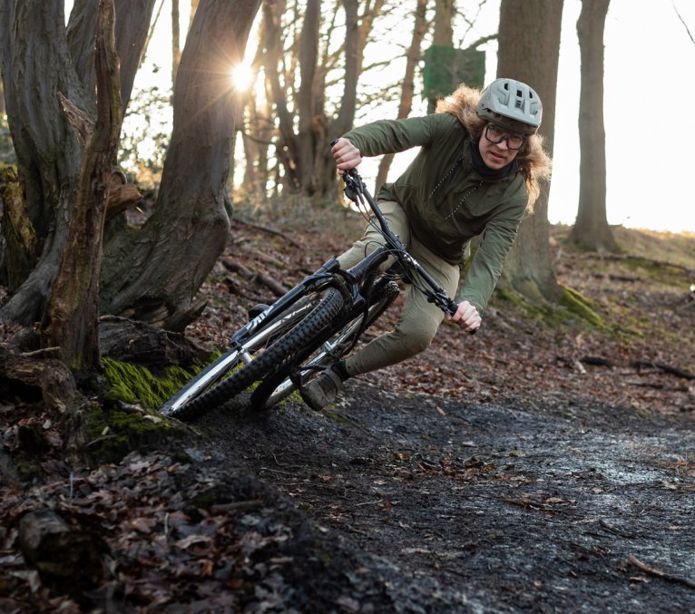 Kai is riding his mountain bike toward the camera. The trail is set in the wintry surroundings of Aachen.