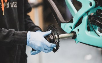 A bc mechanic puts the crank together with the crankshaft into the bottom bracket of a Santa Cruz bike.
