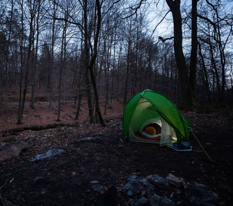 Svenja, de gestión de productos de bc, envuelta en su saco de dormir Deuter en una tienda de campaña de VAUDE.