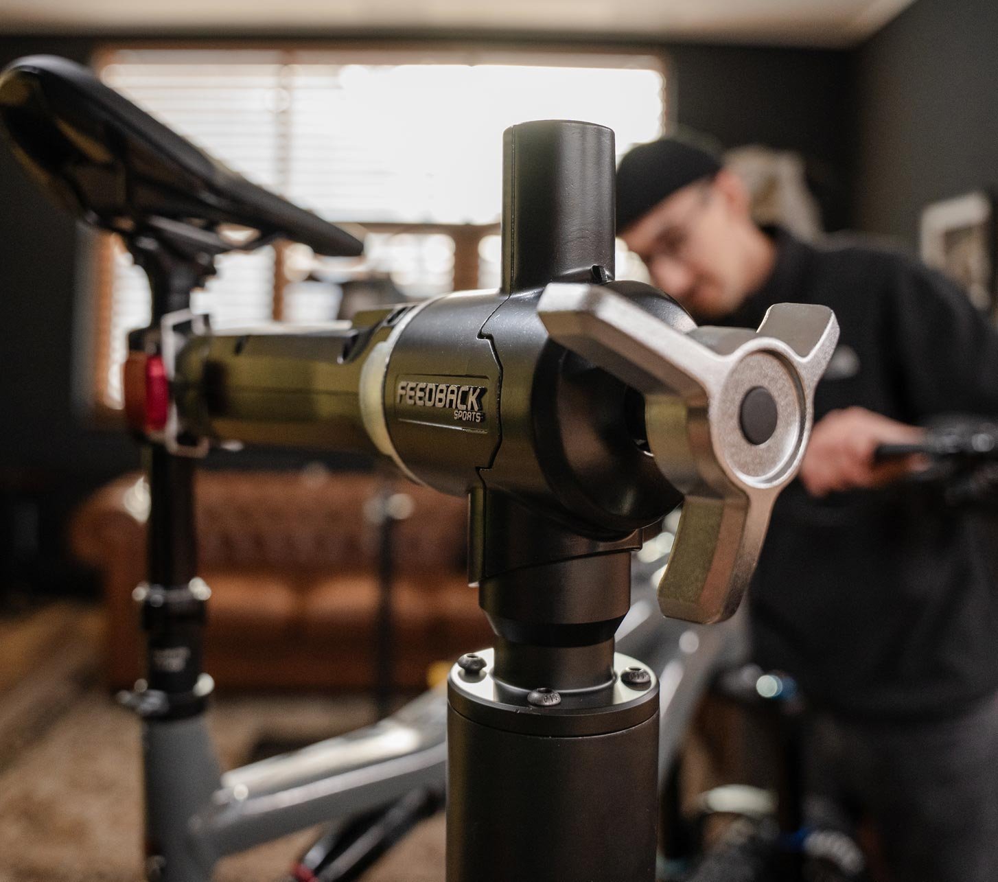 Feedback Sports repair stand with clamp head in a bicycle workshop.