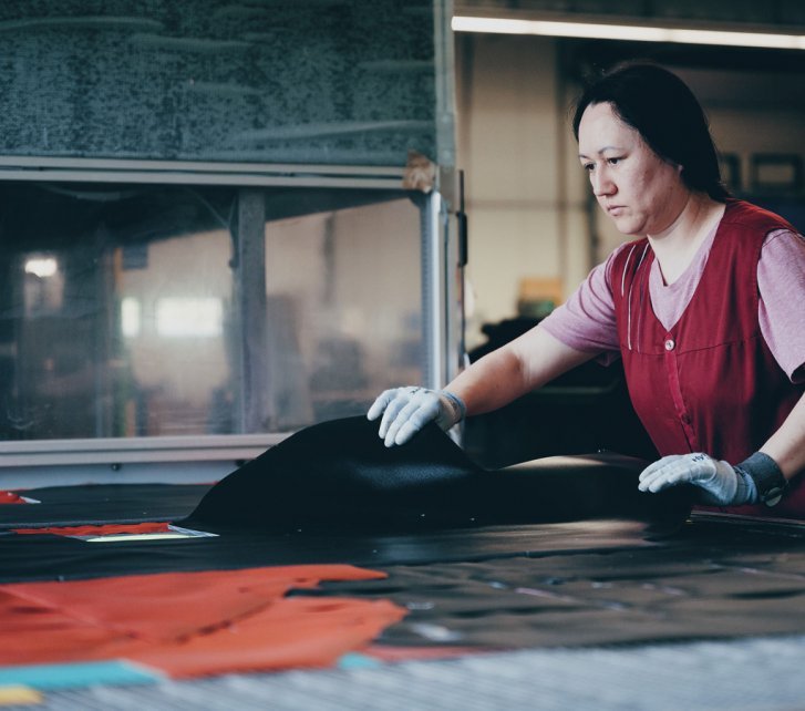 Une collaboratrice d'Ortlieb contrôle les découpes pour un sac.