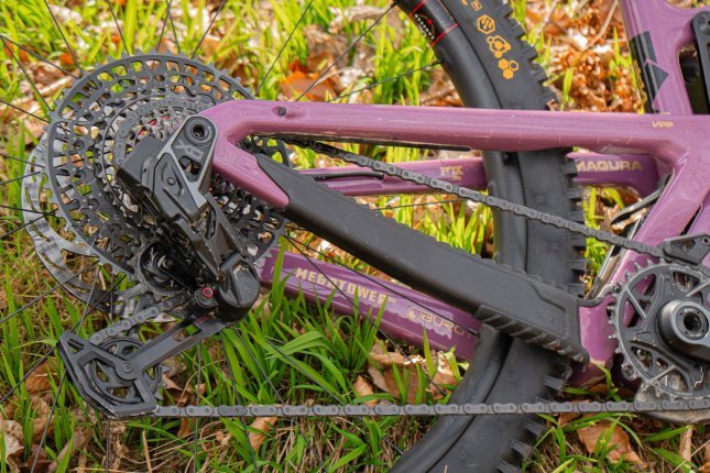 En el triángulo trasero de una MTB púrpura tumbada está montado un grupo de transmisión SRAM AXS.