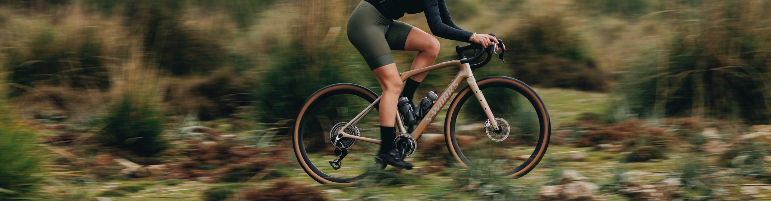 Gravelbikerin fährt ein Specialized Gravelbike in sportlicher Sitzposition auf naturbelassenem Trail – vielseitiges Gravelbike für Abenteuer, Training und lange Touren abseits der Straße.