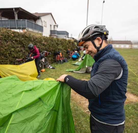 Marcel beim Aufbau seines Zelts. Im Hintergrund baut Linda ihr Biwak auf.