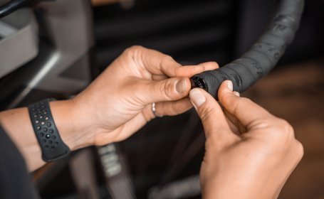 Die Mechanikerin drückt den Lenkerstopfen in den Lenker. 
