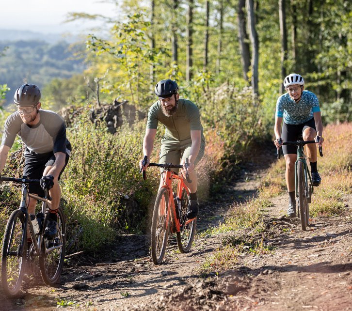 Markus, Björn y Anne, del equipo de bc, en bicis Gravel por un camino forestal. 