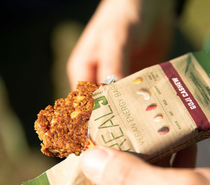 A man opens a Vegan Energy bar from Power Bar.