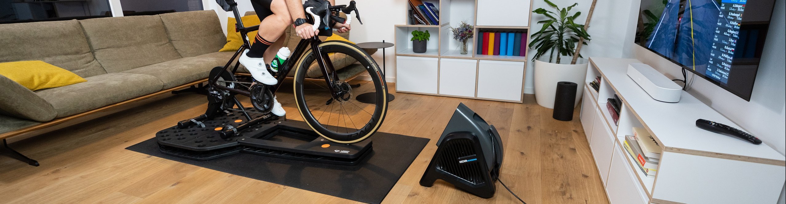 Rennradfahrer sitzt auf Hometrainer mit Leeze Boom Board und trainiert 