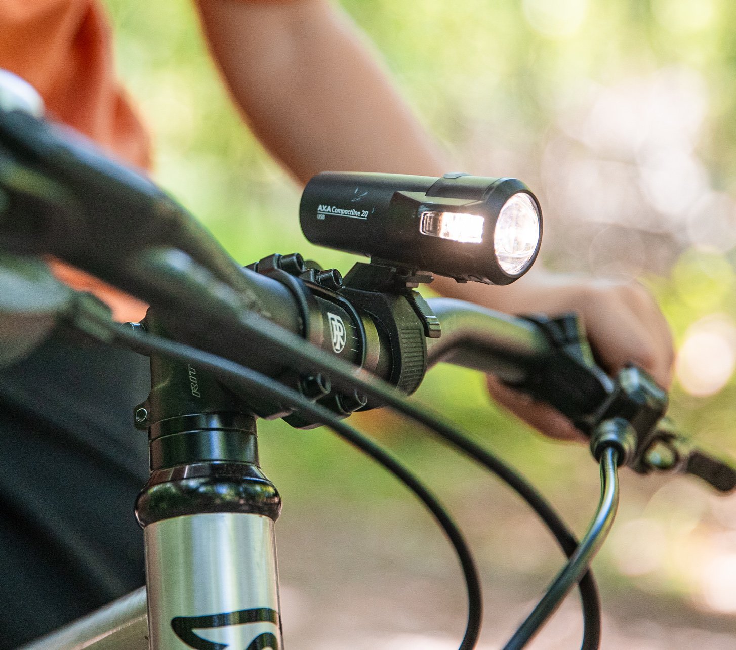 Detailaufnahme eines AXA Compactline Frontlicht am Fahrradlenker montiert