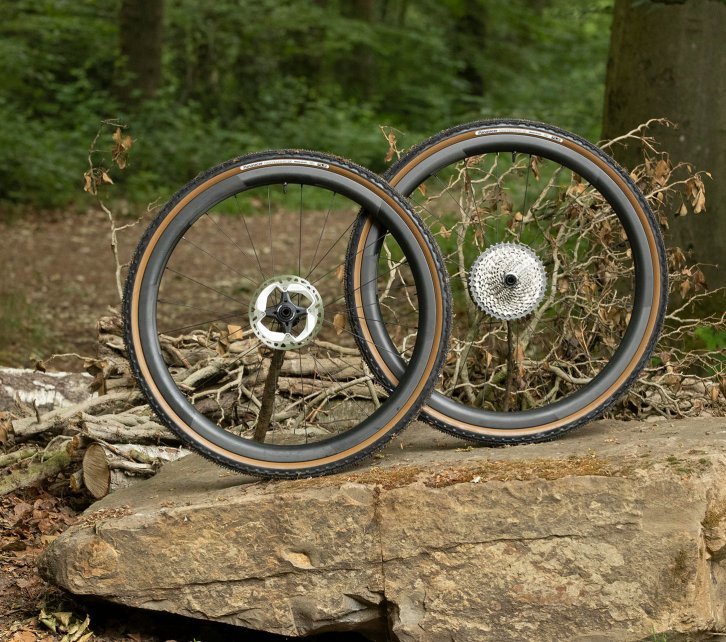Ein Novatec Laufradsatz mit Panaracer Gravelking Reifen drapiert auf einem Stein. 