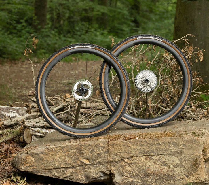 Une paire de roues Novatec avec des pneus Panaracer Gravelking sur une pierre. 