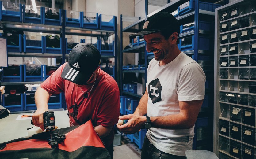 Andi looks over the shoulder of one of the employees while repairing a pannier.