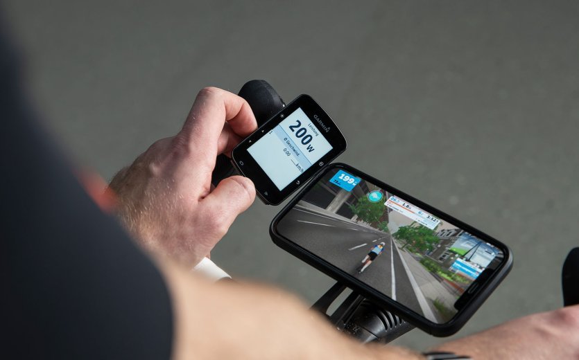 A Garmin Edge bike computer displays performance data in watts during a Zwift workout.