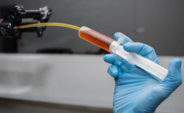 A bc mechanic fills a suspension fork with new fork oil.