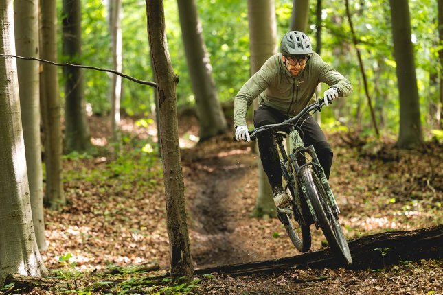 bc-Tester Berno springt mit dem Specialized Turbo Levo R über einen Baumstamm
