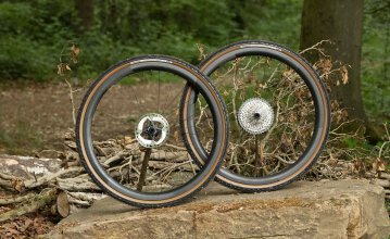 Une paire de roues Novatec avec des pneus Panaracer Gravelking sur une pierre. 