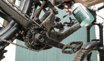 Ein dreckiges Fahrrad wird mit TONIQ Reiniger geputzt. 