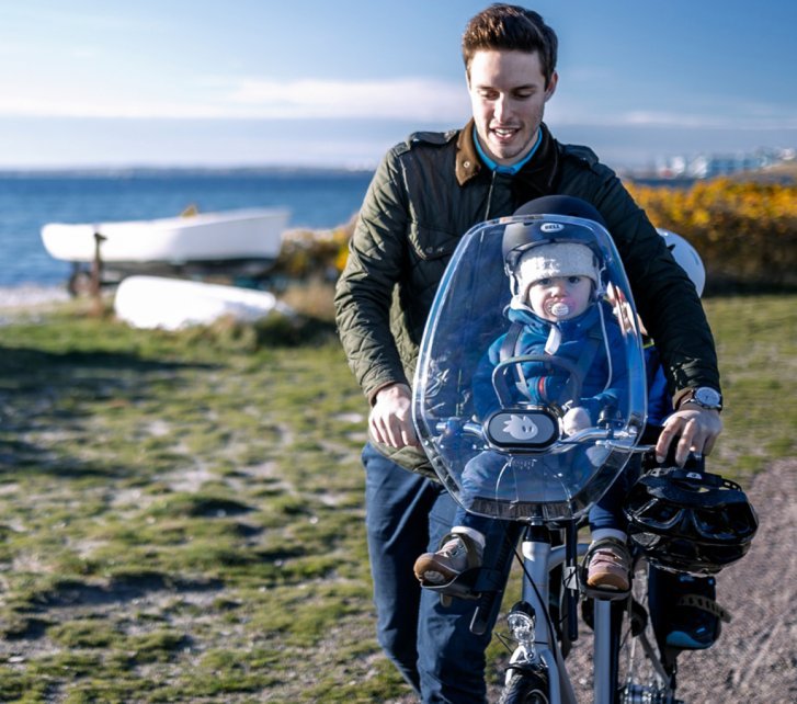 Kleine, leichte Kinder können auch vorn am Lenker sitzen und die volle Aussicht genießen. Ein Windschutz hält Fahrtwind ab.