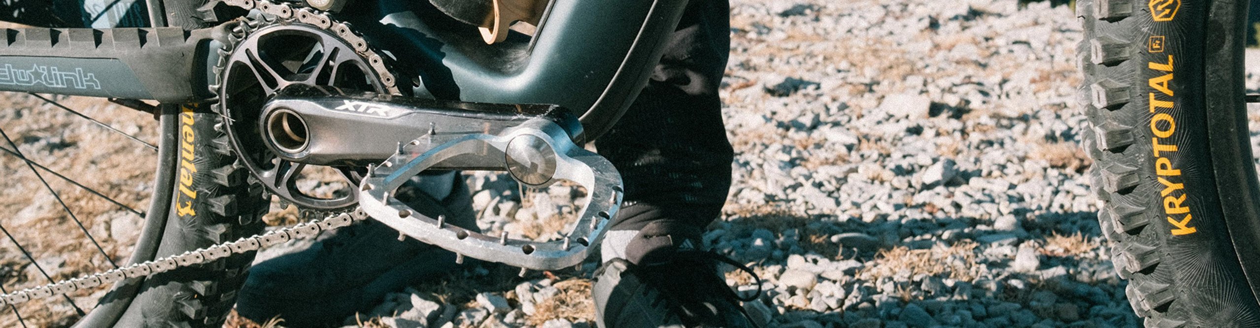 Outlier Void pedals on a mountain bike on a rocky trail with Continental Kryptotal tires in the mountains.