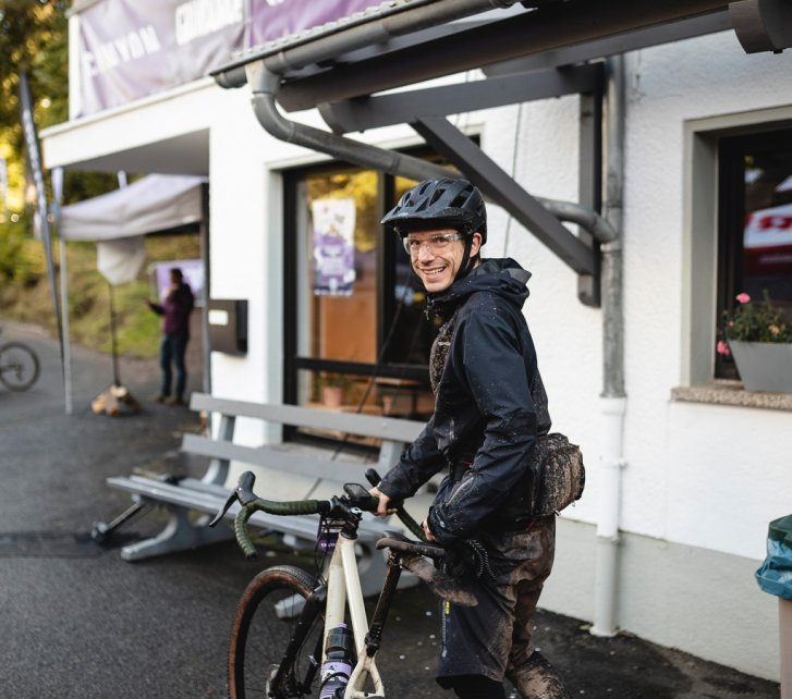 Jan von bc mit Dreck-Spritzern übersät nach Zieleinlauf. Er blickt zurück in die Kamera.