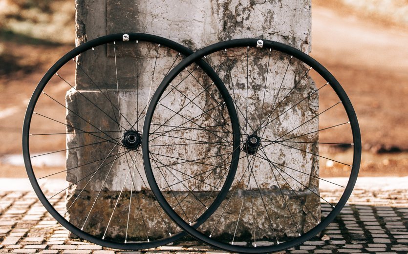 The bc original Loamer wheelset leans against the base of a statue. 