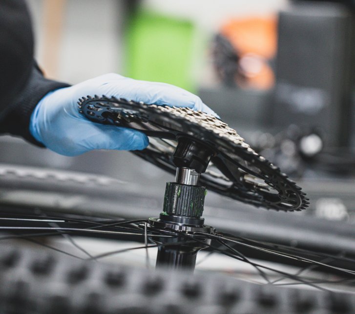 Eine Kassette wird auf den passenden Freilauf eines Mountainbike-Hinterrads montiert.