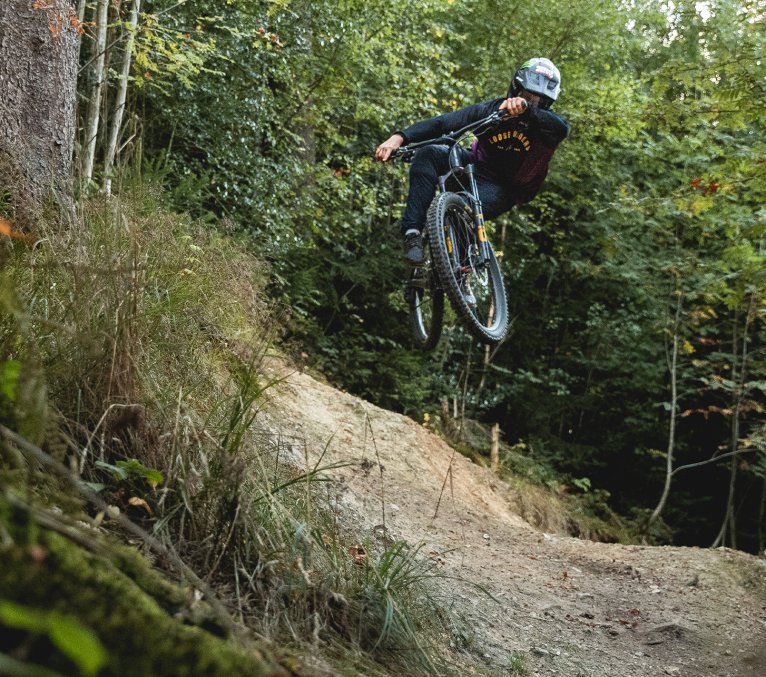 Gravity MTB Fahrer springt in die Höhe