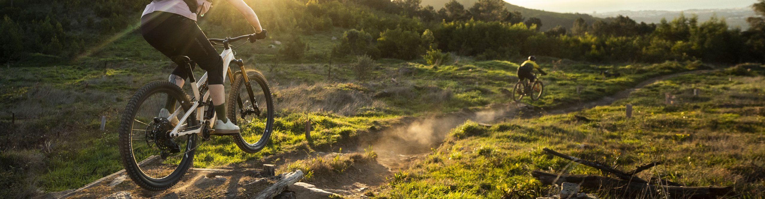 Mountainbiker auf staubigem Trail mit kleinem Kicker