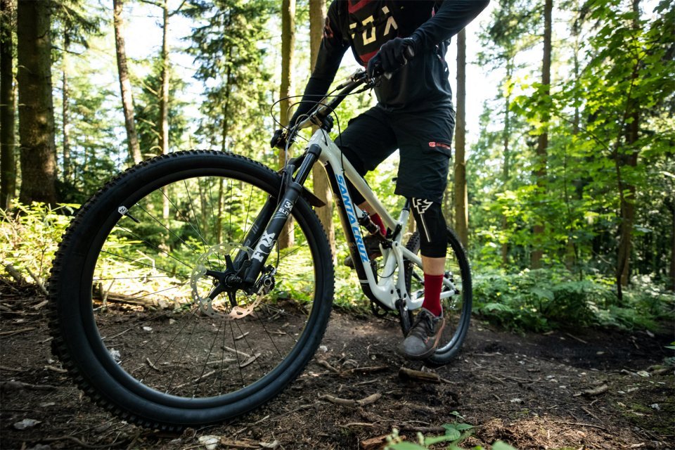 mountain bike rider accelerates in uphill in forest