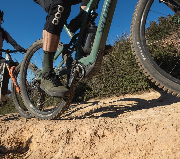 The picture shows the lower part of two e-mountain bikes from Focus and Specialized during a tour over stony ground. 