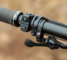 Detailfoto einer linken Lenkerseite beim Turbo Levo 3: An der Remote für das Antriebssystem sind eine Plus- und eine Minustaste erkennbar. 