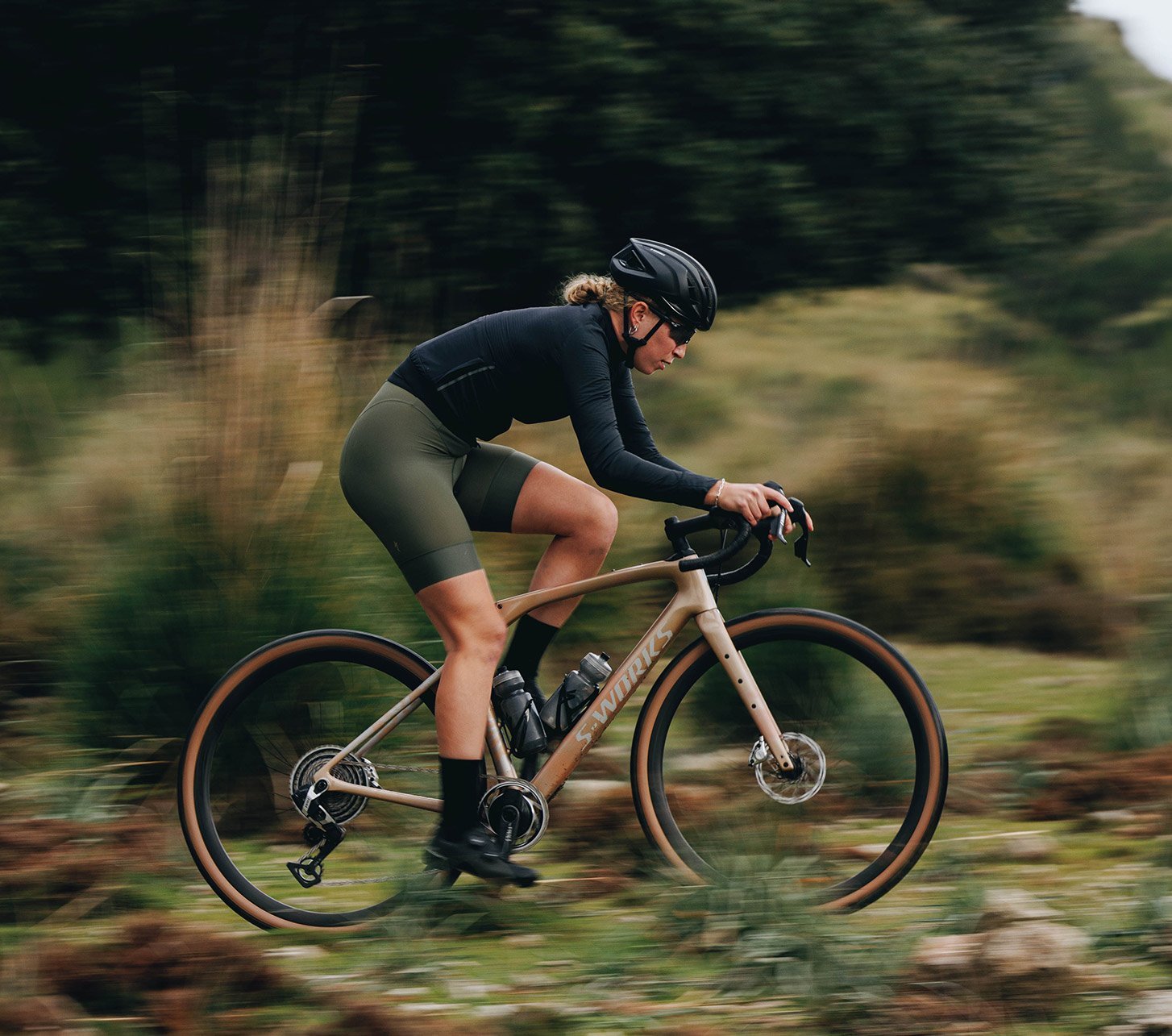 Gravelbikerin fährt ein Specialized Gravelbike in sportlicher Sitzposition auf naturbelassenem Trail – vielseitiges Gravelbike für Abenteuer, Training und lange Touren abseits der Straße.