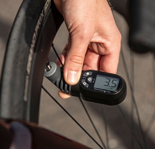 Jonas measures the air pressure of his tyre with a digital gauge. 