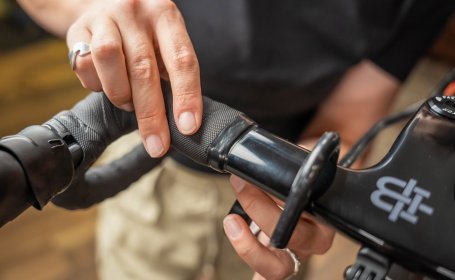 Die Mechanikerin entfernt das Abschlussband des Lenkerbands.