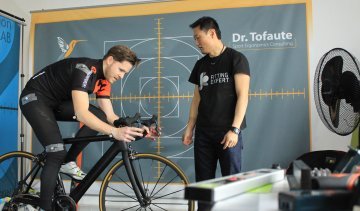 Analyse der Sitzposition am Unterlenker. Kim studiert das Fahrverhalten von Sascha auf dem Rennrad.