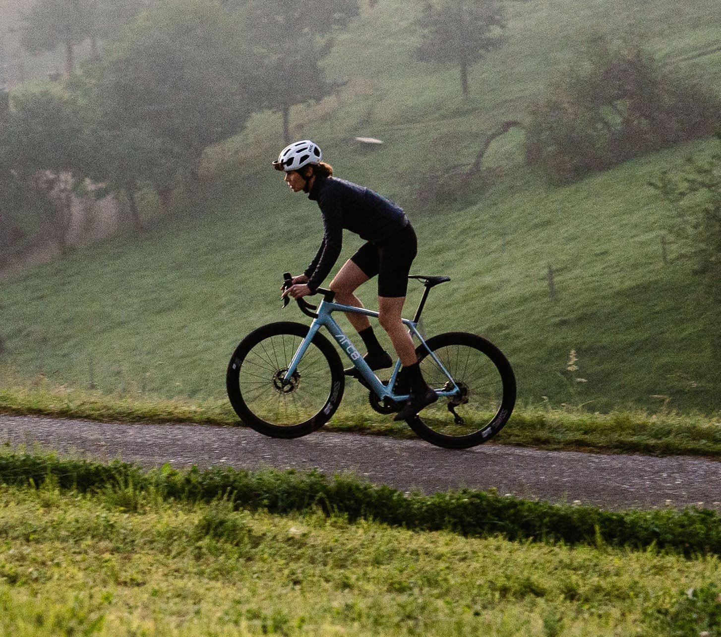ARC8 ESCAPEE DB ULTEGRA Di2 Rennrad in Ice Blue im Einsatz auf einer ruhigen Landstraße – modernes Carbon Rennrad für Performance, Geschwindigkeit und lange Ausfahrten in anspruchsvollem Terrain.