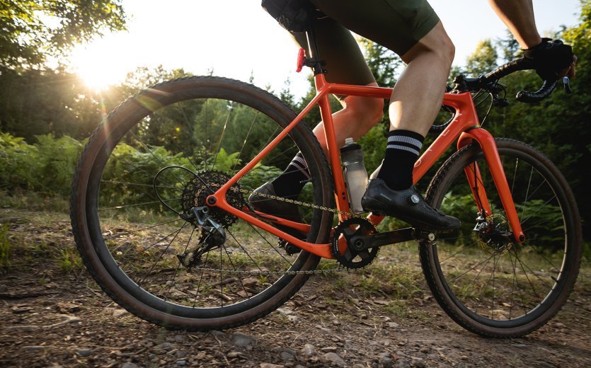 Björn from bc rides his OPEN gravel bike along a forest path. 