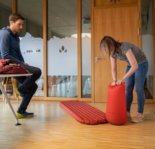 bc-Brandmanagerin Svenja befüllt eine Isomatte mit Hilfe eines Pumpsacks.