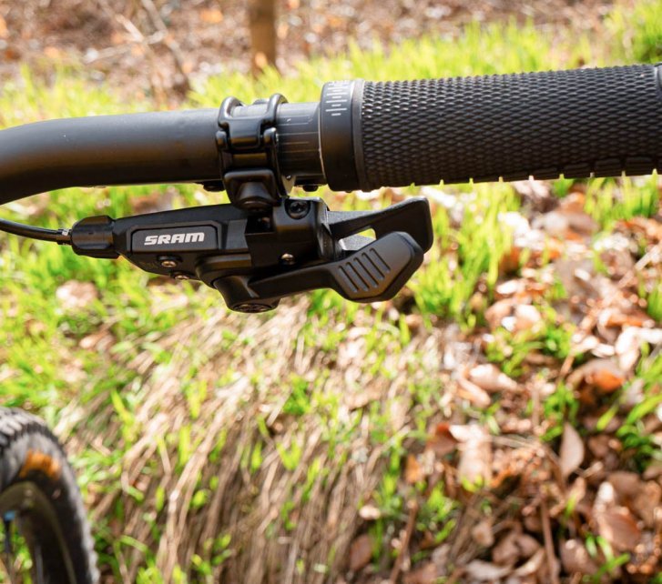 En el extremo derecho del manillar de una MTB está montado el controlador mecánico de una transmisión SRAM Eagle.