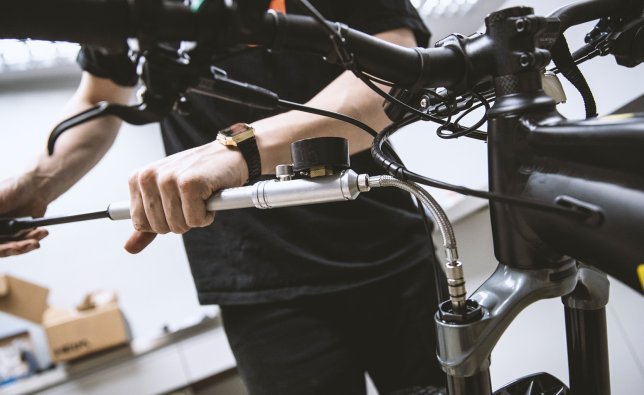 A bc mechanic optimises the suspension stiffness on an MTB using a suspension fork and shock pump. 