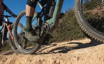 The picture shows the lower part of two e-mountain bikes from Focus and Specialized during a tour over stony ground. 