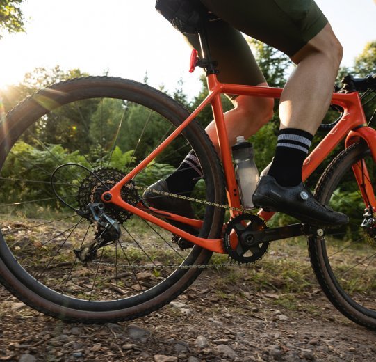  Björn from bc rides his OPEN gravel bike along a forest path. 