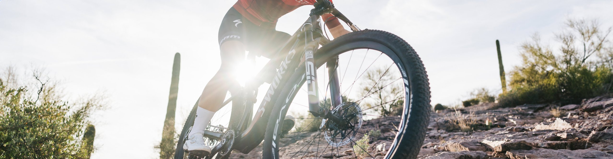 Mountainbikerin fährt durch einen Wüsten-Trail